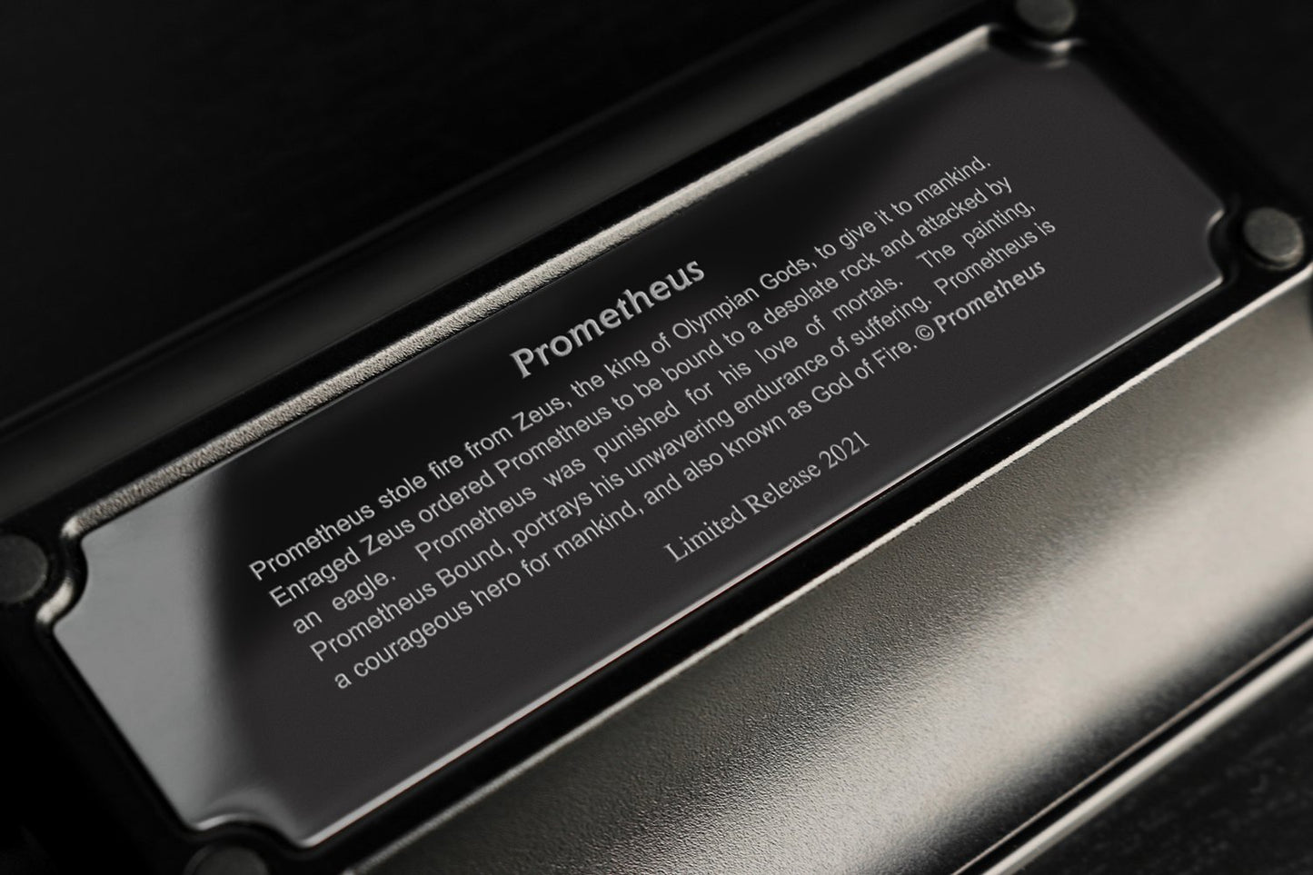 The back of a modern black matte metal ashtray. The brand is Prometheus. The photo describes the life of Greek God Prometheus for which the cigar accessory line was named. Prometheus stole fire from Zeus to give to mankind. 